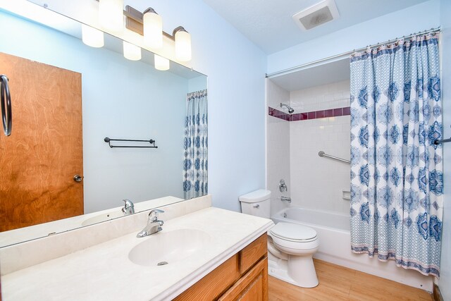 full bathroom featuring vanity, wood-type flooring, shower / bath combo, and toilet