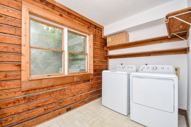 clothes washing area with a textured ceiling and independent washer and dryer