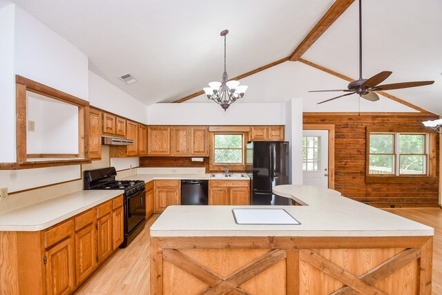 kitchen with sink, pendant lighting, a breakfast bar area, black appliances, and light wood-type flooring