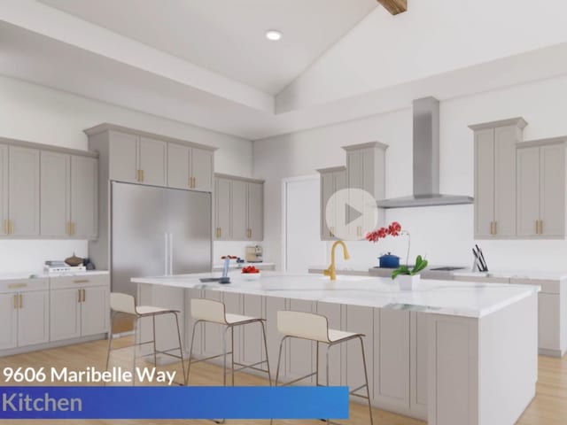 kitchen featuring gray cabinetry, a center island with sink, wall chimney exhaust hood, and light wood-type flooring