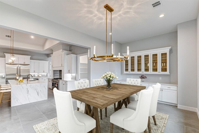 tiled dining room featuring a chandelier and sink