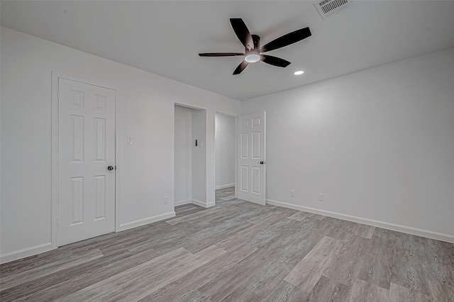 unfurnished bedroom with ceiling fan, light wood-type flooring, and a closet