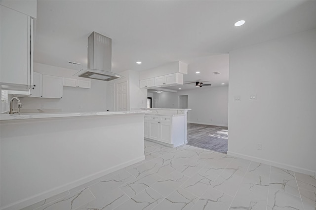 kitchen with white cabinetry, sink, ceiling fan, kitchen peninsula, and island range hood