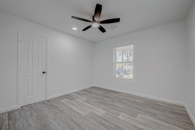 spare room with ceiling fan and light wood-type flooring