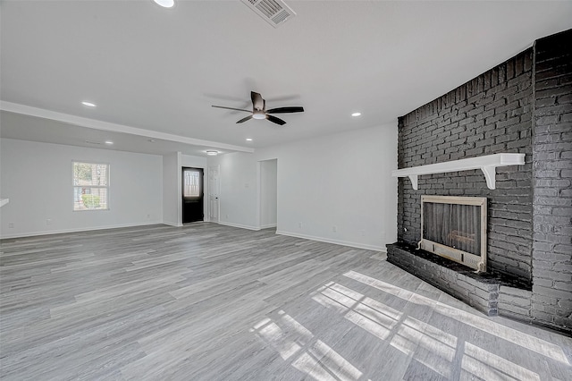 unfurnished living room featuring ceiling fan, light hardwood / wood-style floors, and a fireplace