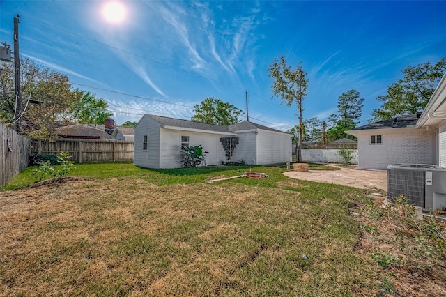 view of yard featuring central AC unit, an outdoor structure, and a patio