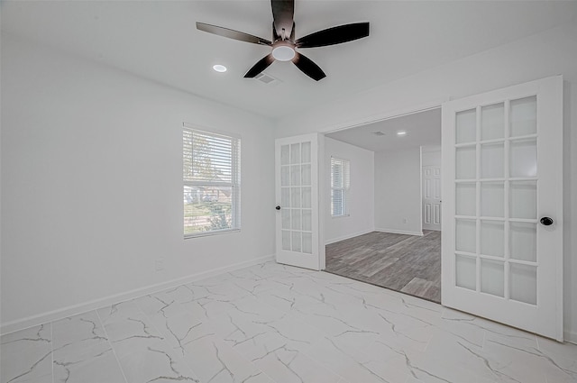 empty room with ceiling fan, french doors, and light wood-type flooring