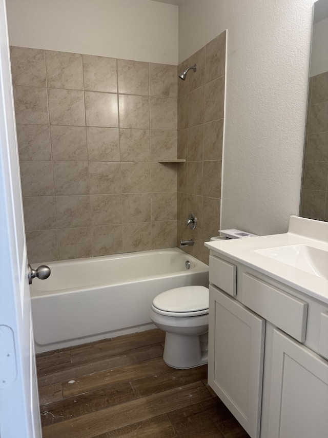 full bathroom with hardwood / wood-style floors, vanity, toilet, and tiled shower / bath