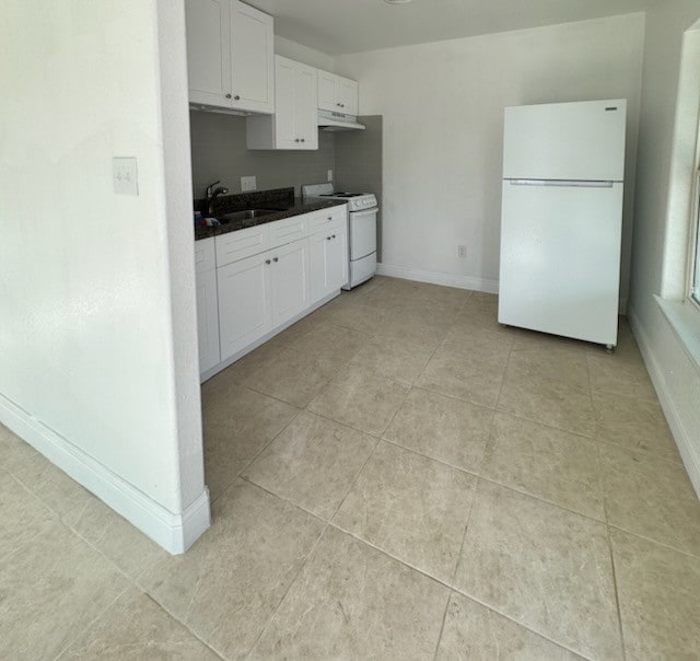 kitchen featuring light tile patterned flooring, white appliances, white cabinetry, and sink