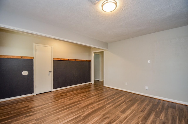 spare room with dark hardwood / wood-style flooring and a textured ceiling