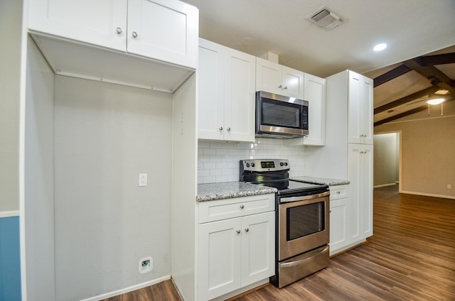 kitchen with light stone countertops, appliances with stainless steel finishes, dark wood-type flooring, beam ceiling, and white cabinets