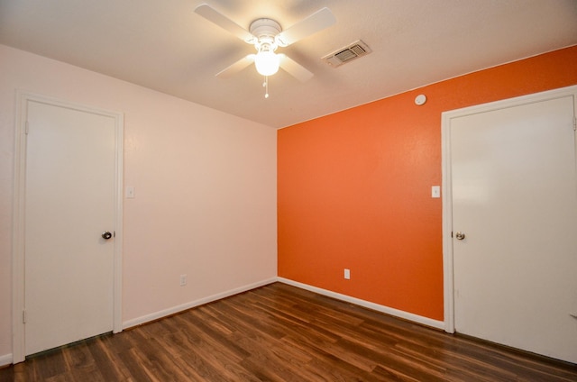 spare room with ceiling fan and dark wood-type flooring