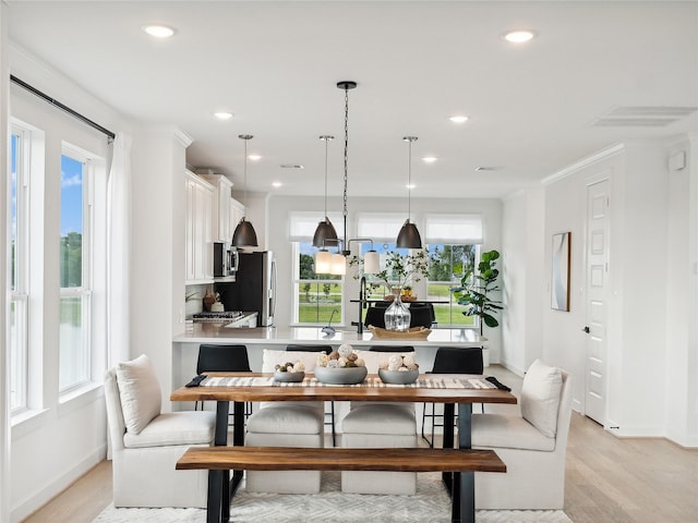 dining area featuring light hardwood / wood-style floors and ornamental molding