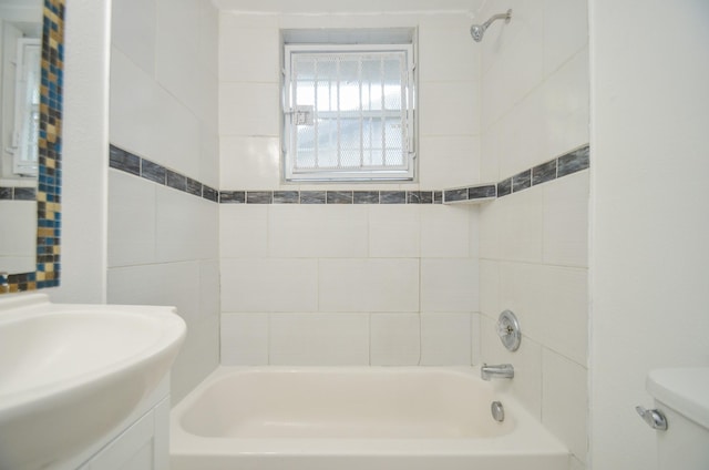 full bathroom featuring tiled shower / bath combo, toilet, and vanity