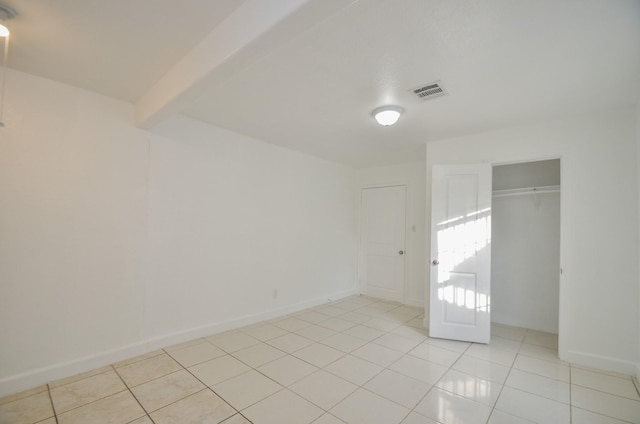 unfurnished bedroom featuring a closet and light tile patterned flooring