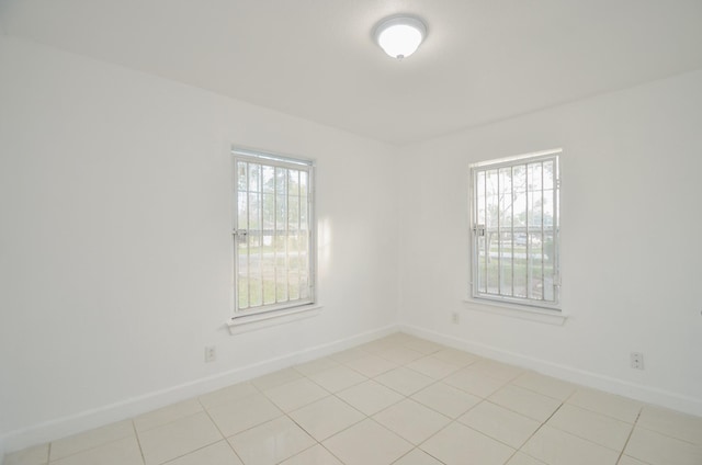 empty room featuring plenty of natural light and light tile patterned floors