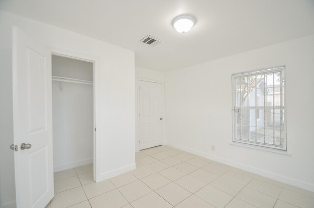 unfurnished bedroom with a closet and light tile patterned flooring