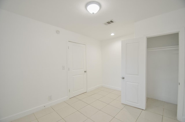 unfurnished bedroom with light tile patterned floors and a closet