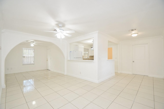 unfurnished room with ceiling fan, crown molding, and light tile patterned flooring