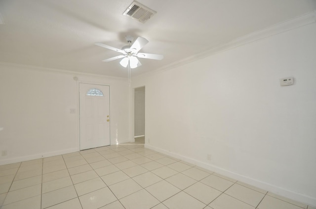 spare room with ceiling fan, ornamental molding, and light tile patterned flooring