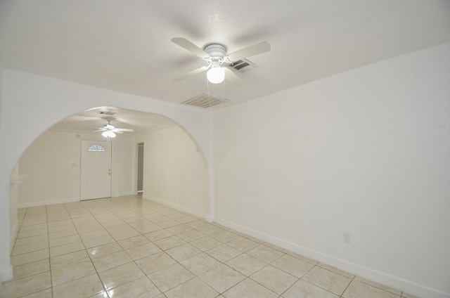 empty room with ceiling fan and light tile patterned floors