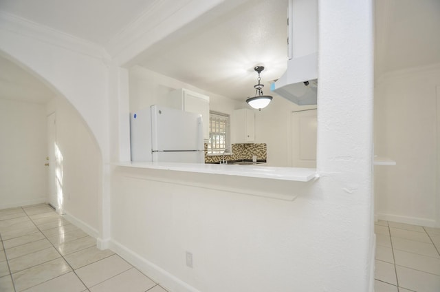 kitchen with white cabinets, light tile patterned floors, white refrigerator, and hanging light fixtures