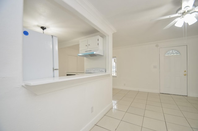 interior space featuring light tile patterned floors, white fridge, white cabinetry, and ornamental molding