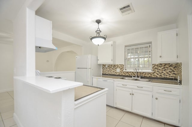 kitchen featuring white appliances, white cabinetry, hanging light fixtures, and sink