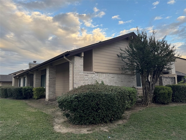 property exterior at dusk featuring a yard