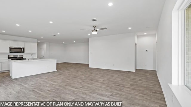 kitchen featuring stainless steel appliances, a kitchen island with sink, ceiling fan, light hardwood / wood-style flooring, and white cabinets