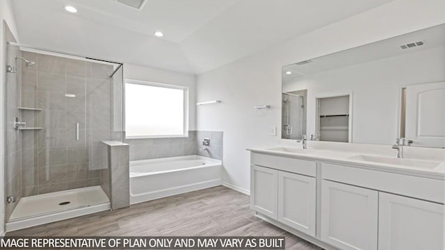 bathroom featuring vanity, wood-type flooring, vaulted ceiling, and shower with separate bathtub