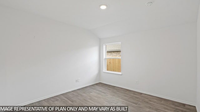 unfurnished room featuring hardwood / wood-style floors and lofted ceiling