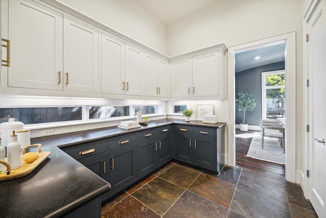 kitchen with white cabinetry and lofted ceiling