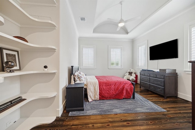 bedroom with dark hardwood / wood-style floors, ceiling fan, and a tray ceiling