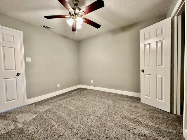 carpeted spare room with ceiling fan and a textured ceiling