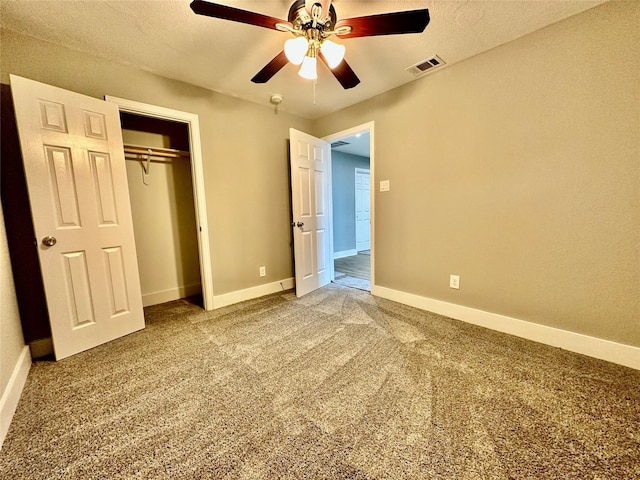 unfurnished bedroom with a textured ceiling, carpet floors, a closet, and ceiling fan