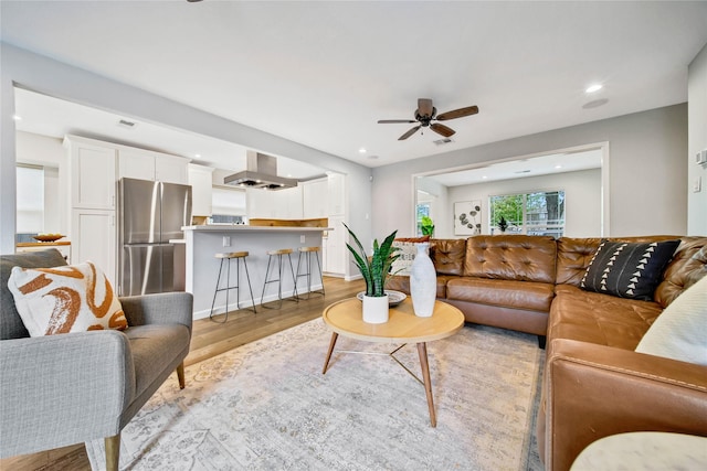 living room featuring ceiling fan and light hardwood / wood-style flooring