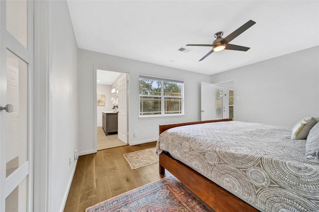 bedroom featuring light hardwood / wood-style floors, ensuite bath, and ceiling fan