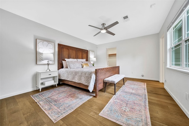 bedroom with hardwood / wood-style floors, a spacious closet, and ceiling fan