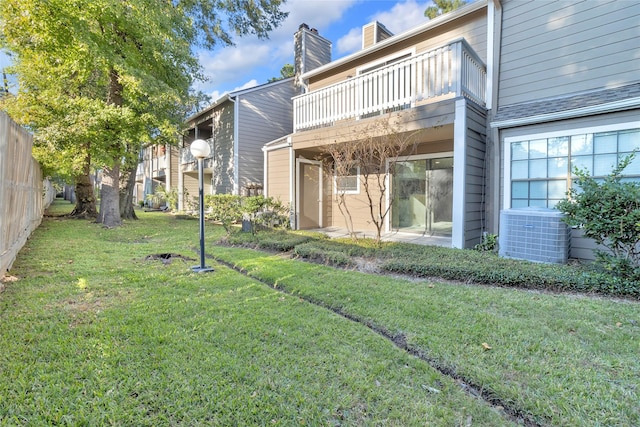 view of yard featuring a balcony and central AC