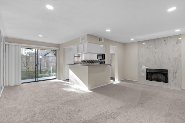 unfurnished living room featuring a fireplace and light colored carpet