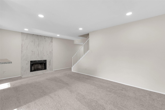 unfurnished living room featuring a premium fireplace and carpet