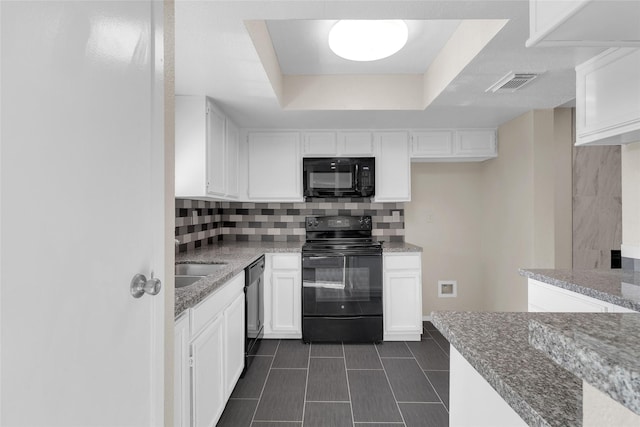 kitchen featuring backsplash, white cabinetry, light stone countertops, and black appliances