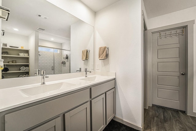 bathroom with hardwood / wood-style floors, vanity, and a shower with shower door