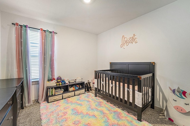 carpeted bedroom featuring multiple windows and a crib