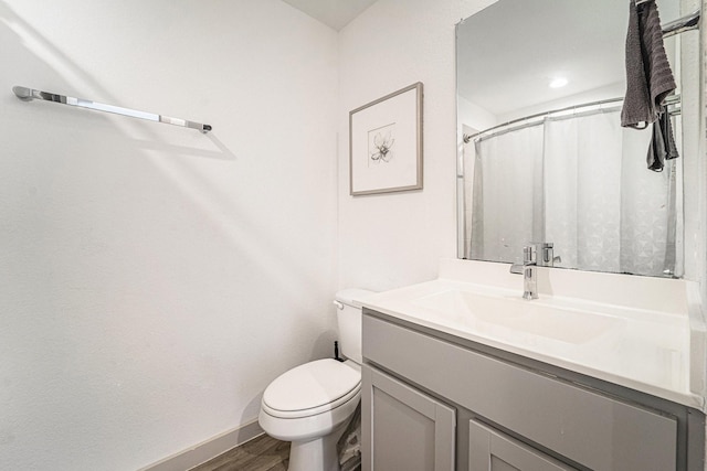 bathroom with a shower with curtain, hardwood / wood-style floors, vanity, and toilet