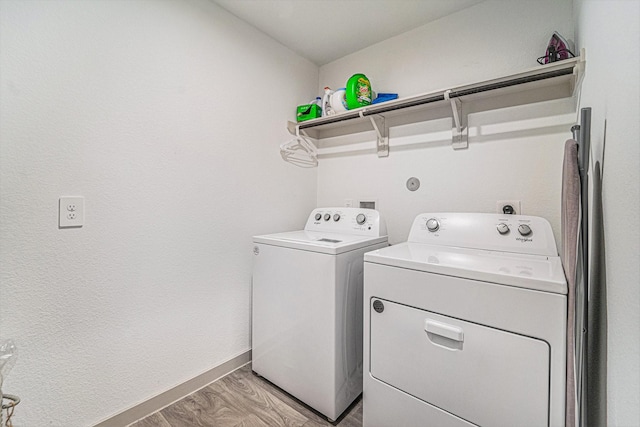 laundry room with independent washer and dryer and light wood-type flooring