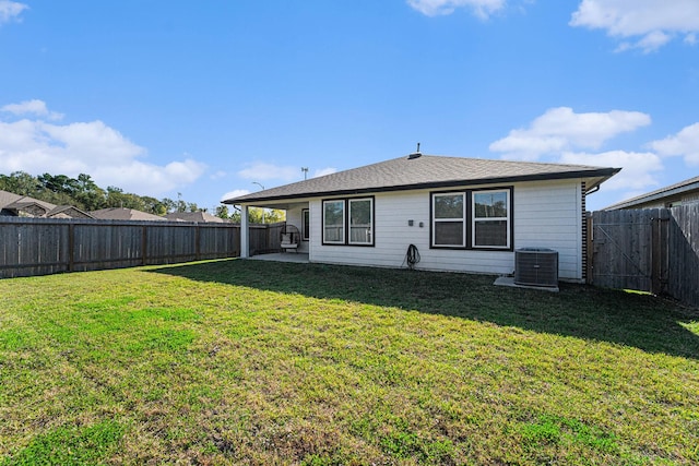 back of house featuring a lawn, a patio area, and central AC