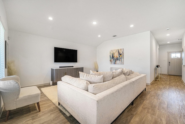 living room with light hardwood / wood-style floors and vaulted ceiling