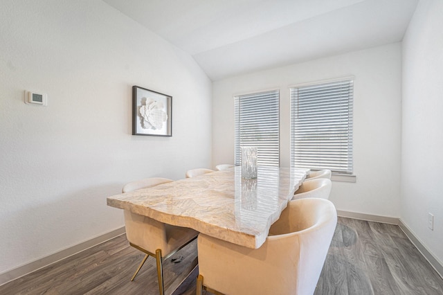 dining space with dark wood-type flooring and vaulted ceiling